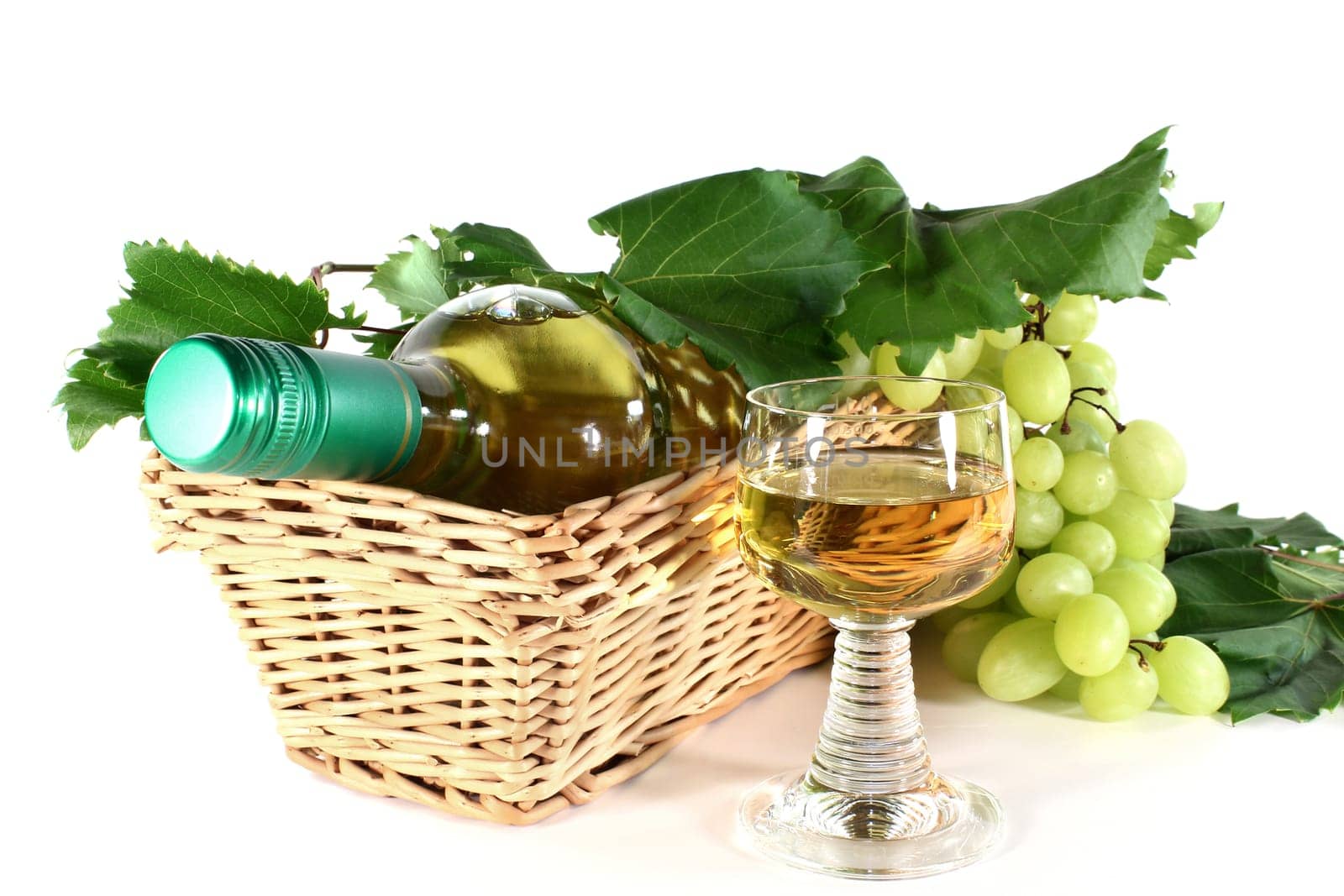 a bottle of white wine and fresh grapes against a white background