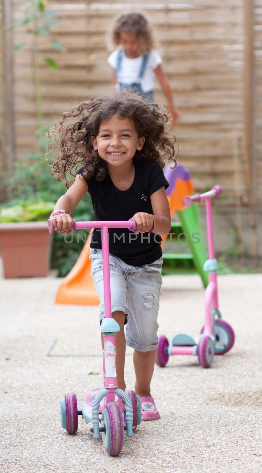 Smiling girl playing with a scooter