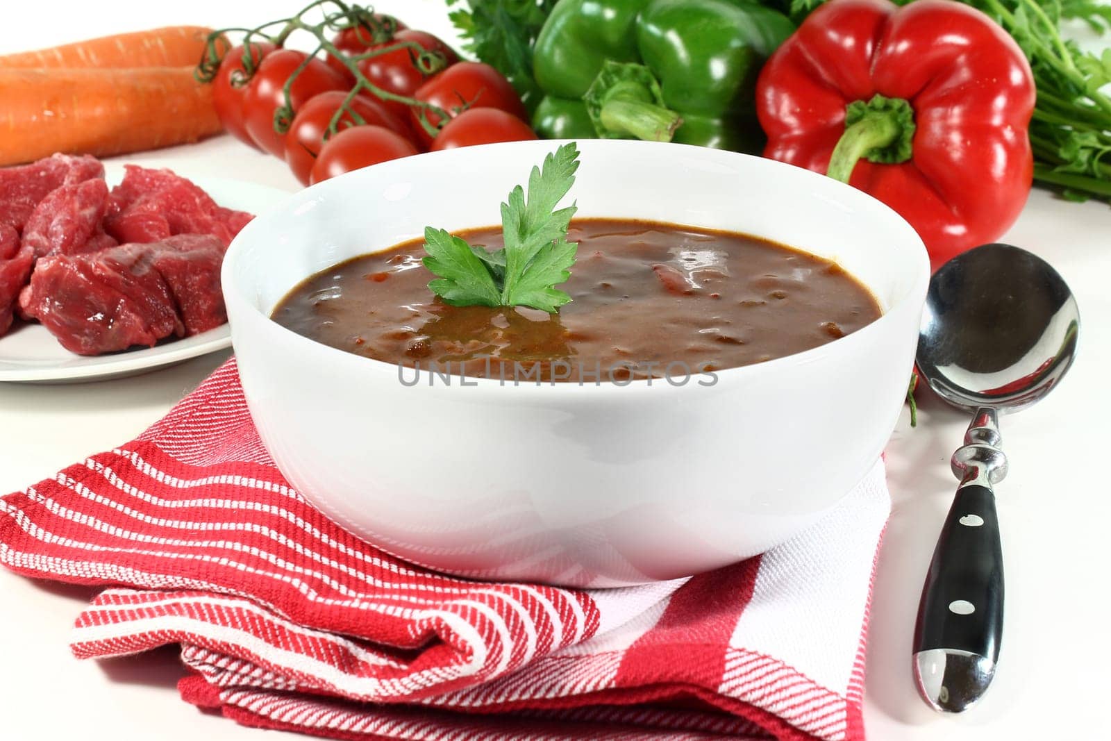 a bowl of goulash soup and fresh ingredients