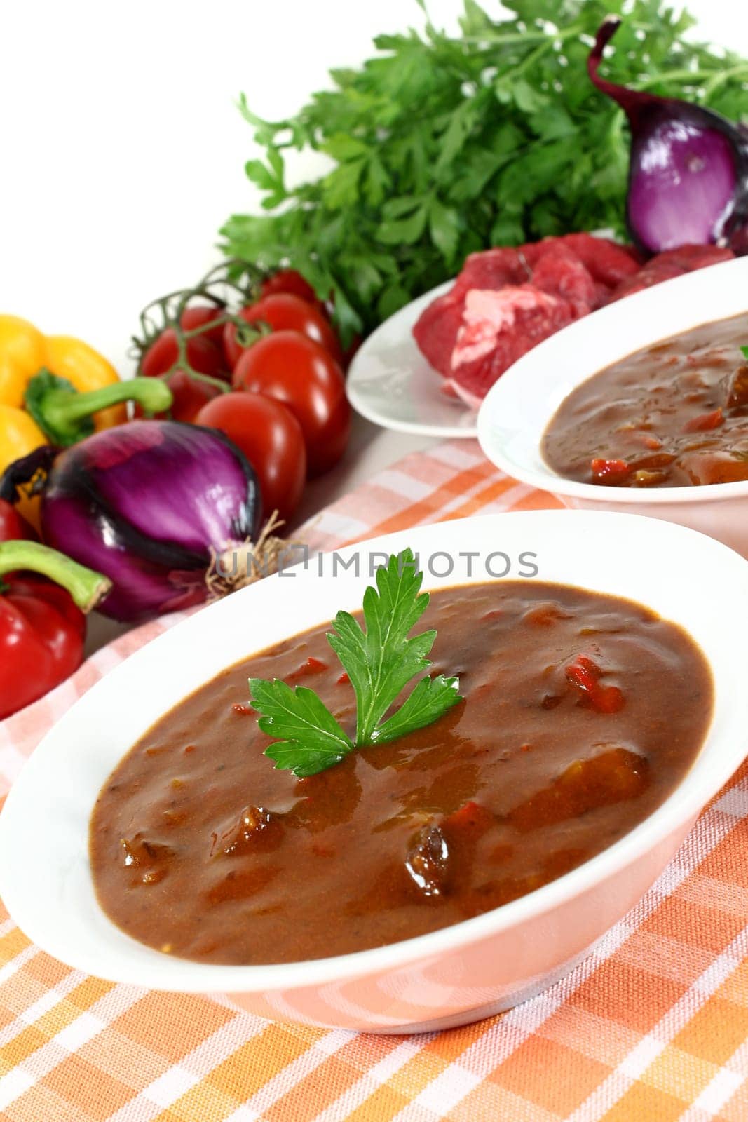 a bowl of goulash soup and fresh ingredients