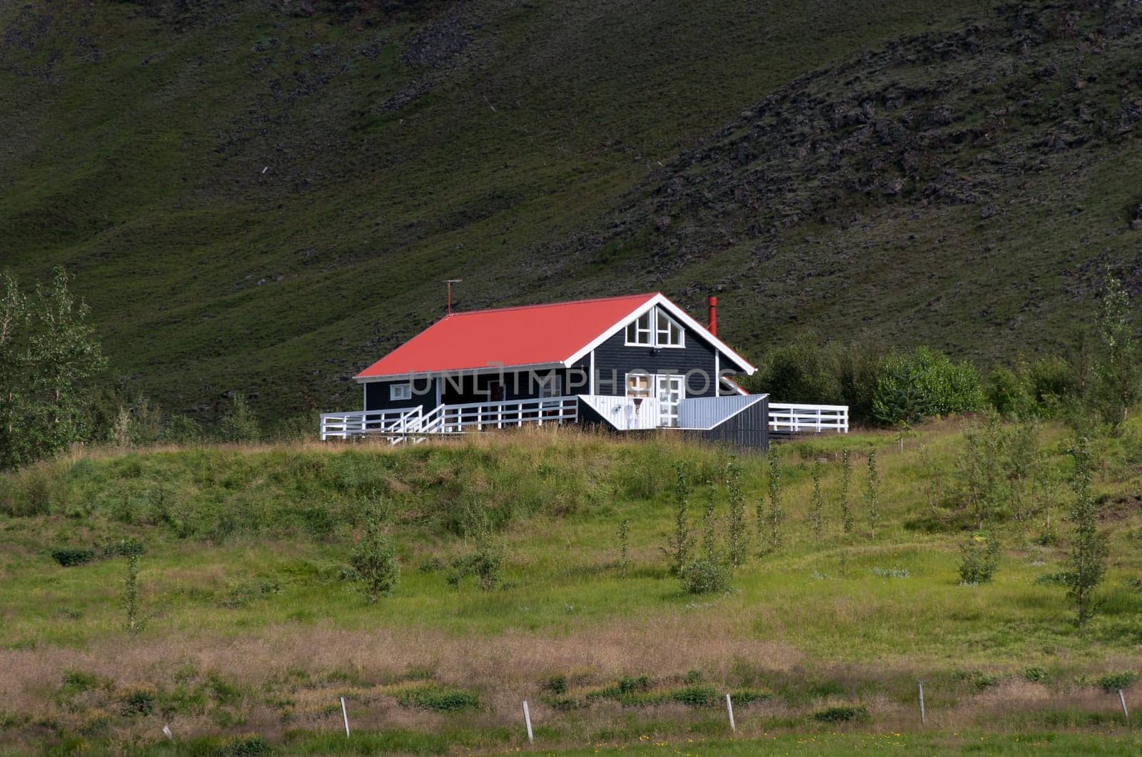 black house with red roof and white trim in Iceland
