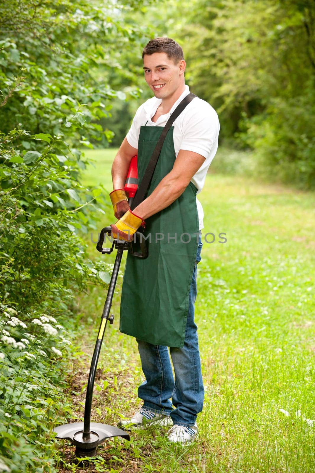 Young gardener with a lawn trimmer