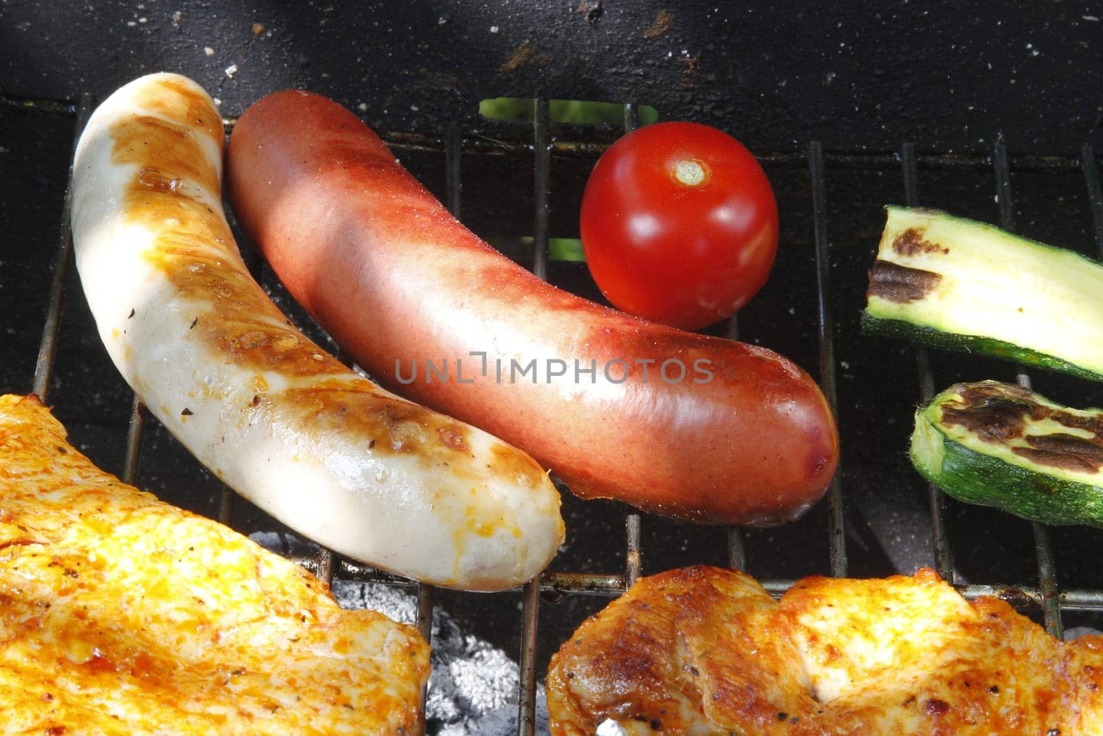 Meat slices,sausages and vegetables on the charcoal grill