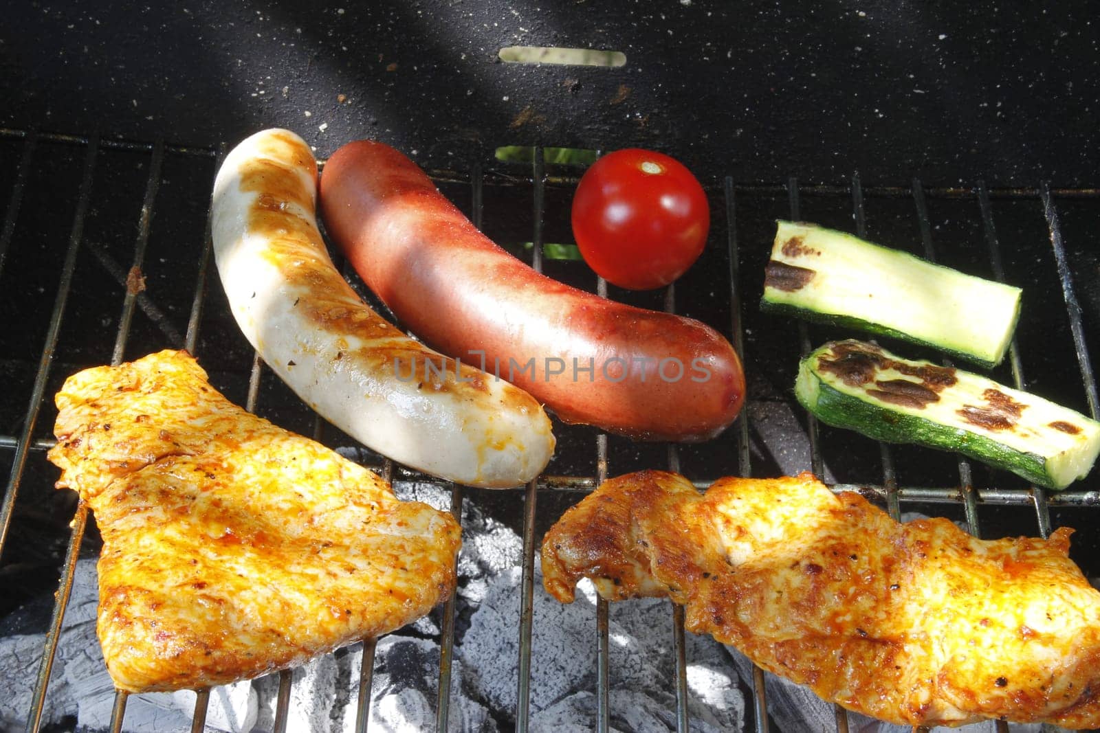 Meat slices,sausages and vegetables on the charcoal grill