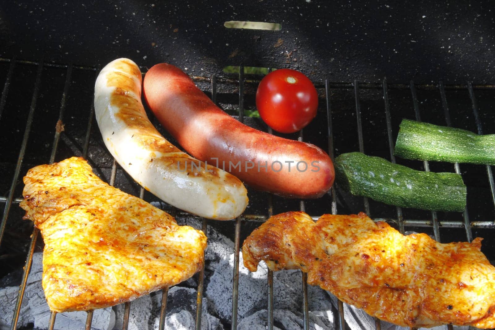 Meat slices,sausages and vegetables on the charcoal grill