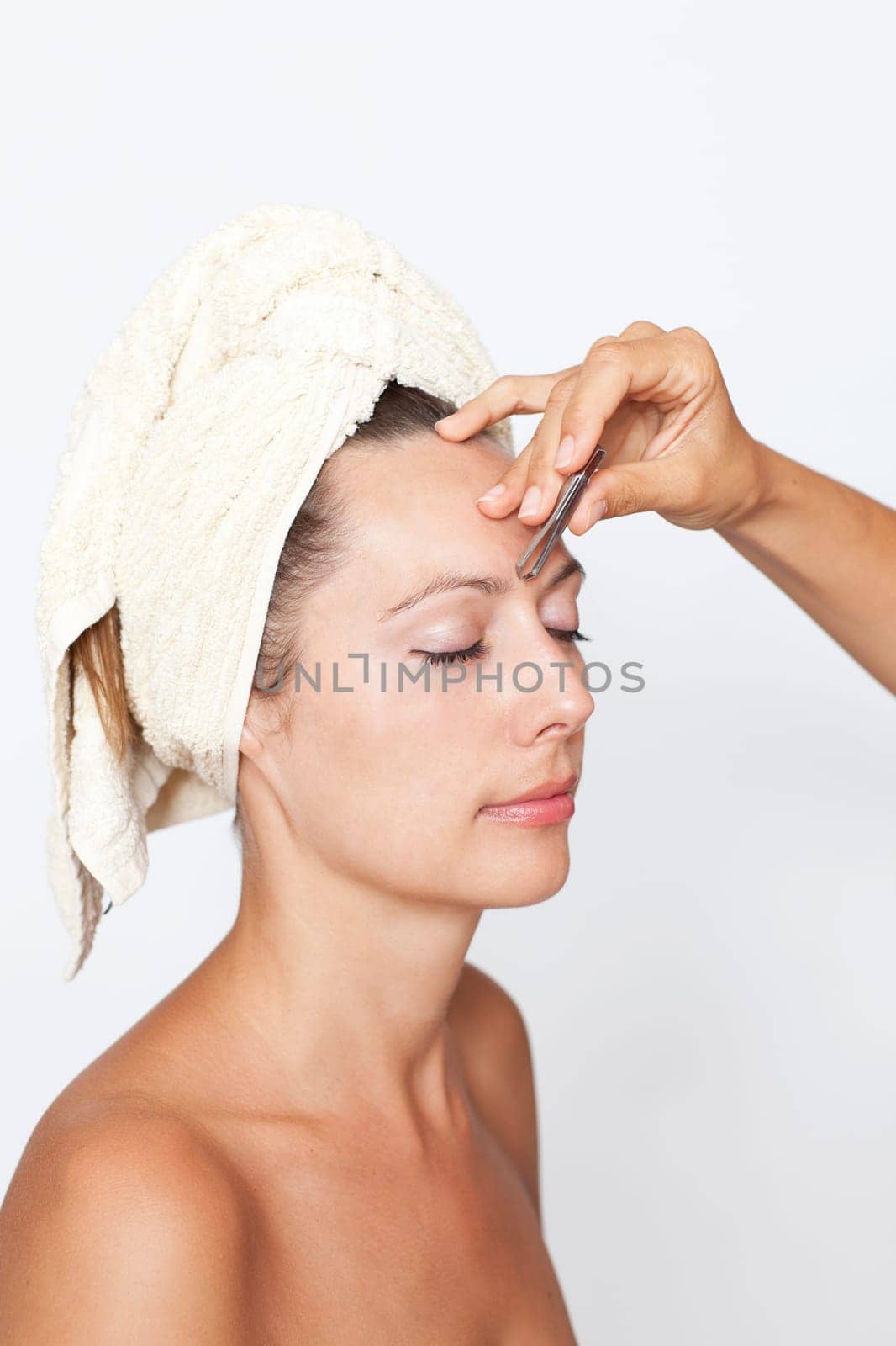 Woman plucking eyebrows