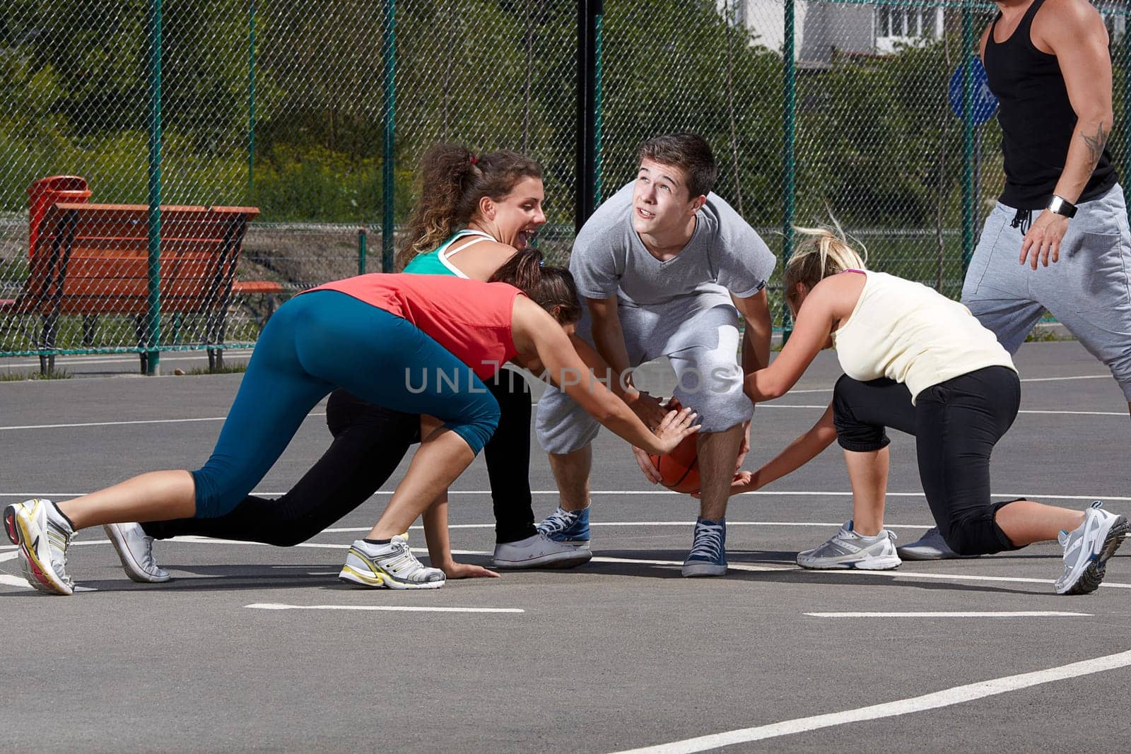 Young people playing basketball in a park