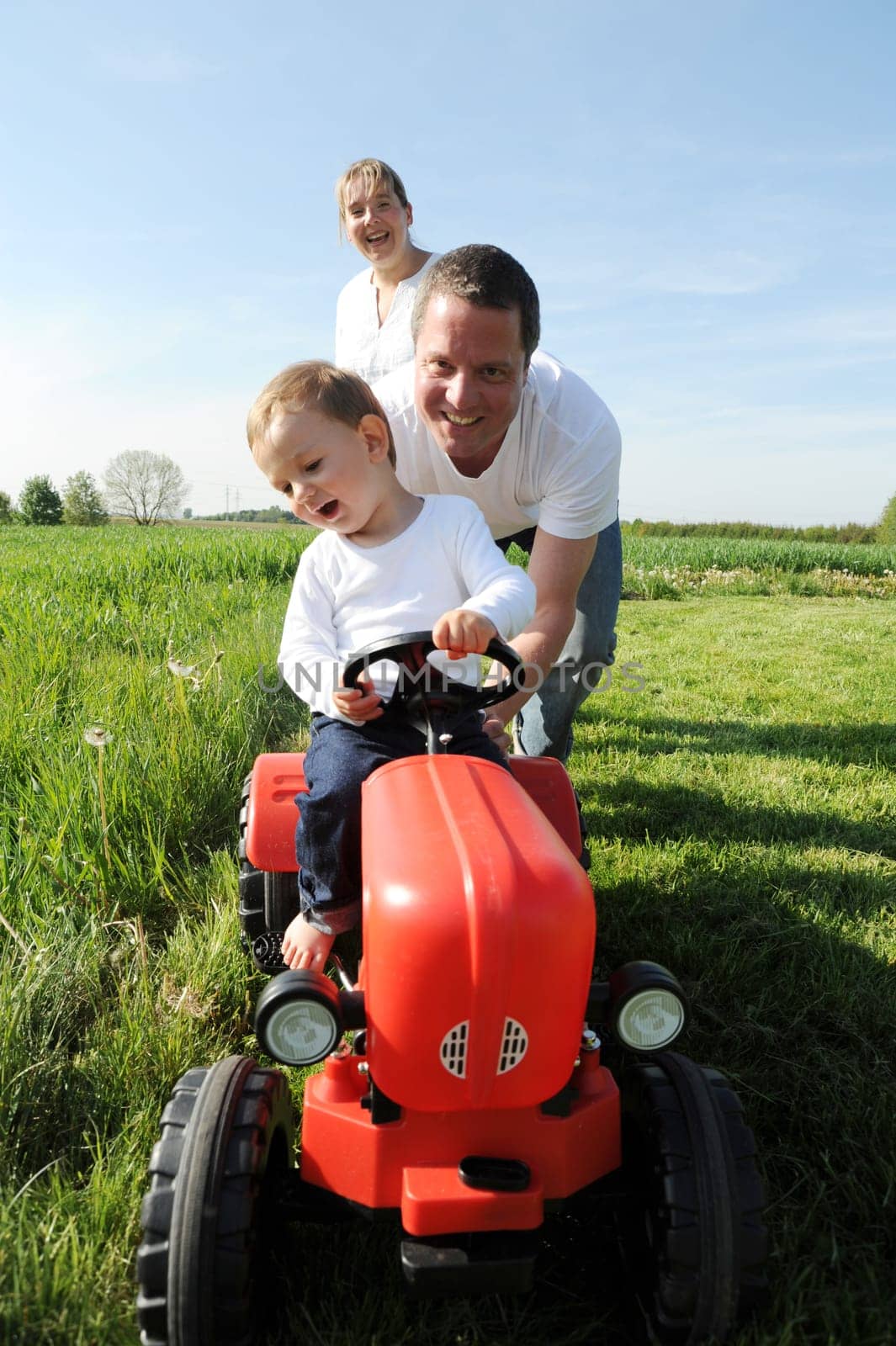 Parents and toddler with red tractor