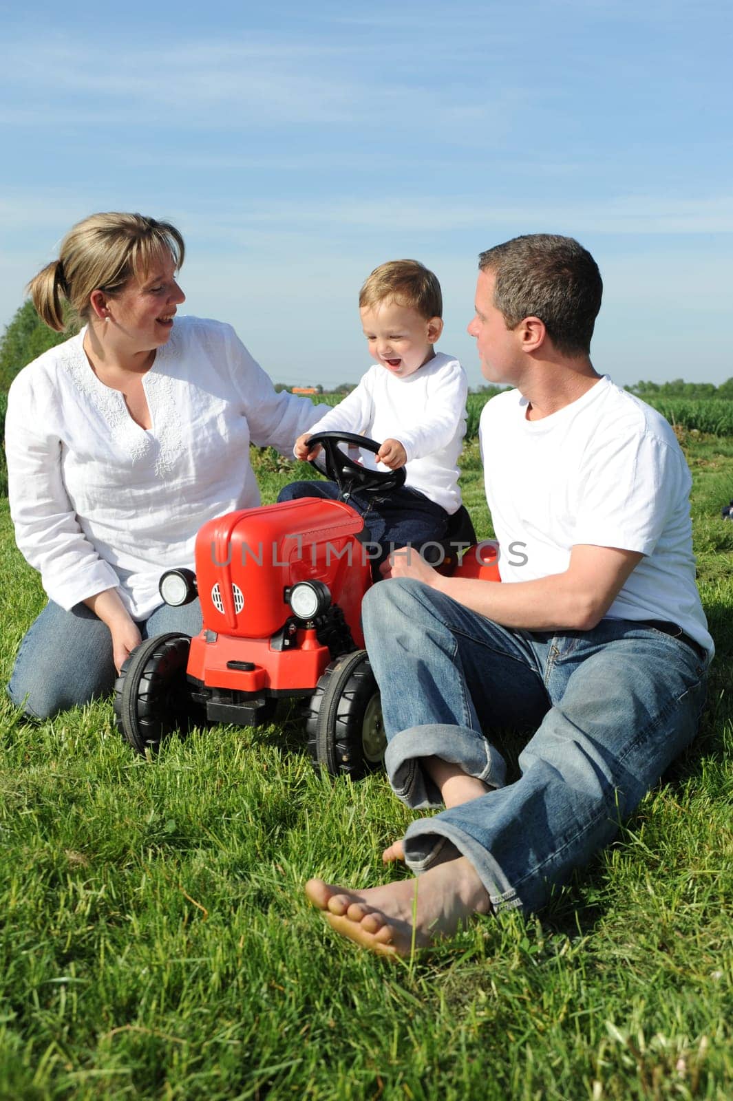 Parent and child with red toy tractor