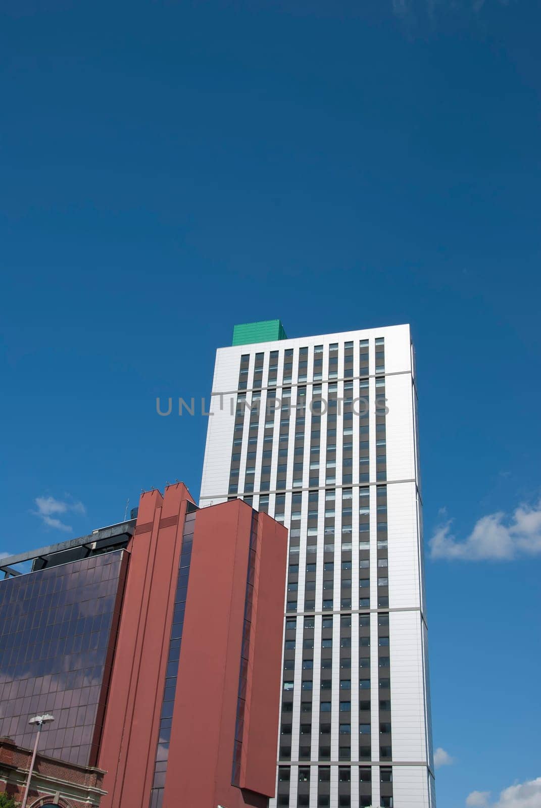 Two Red Brick and White Tower Blocks under a blue summer sky
