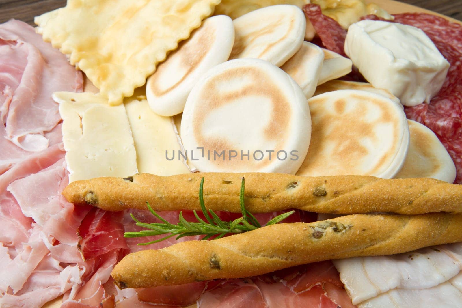 a platter of mixed cured meats, cheeses and fried dumpling
