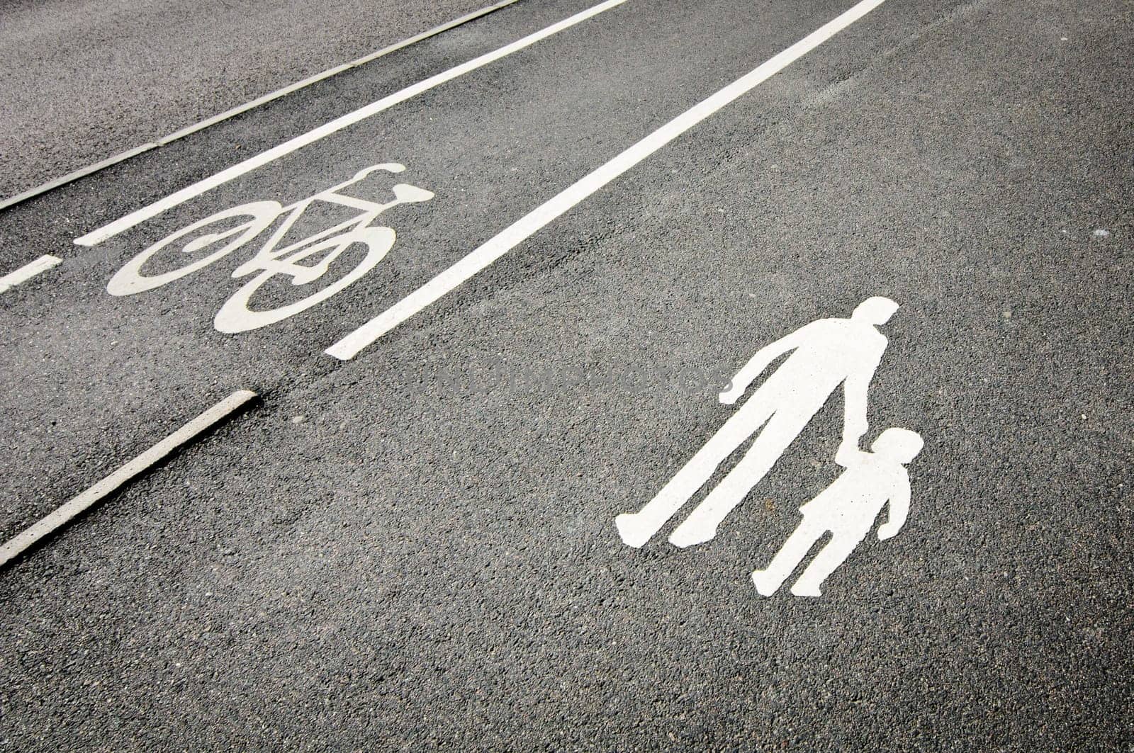 Painted signs on asphalt for pedestrian and bicycle dedicated lanes