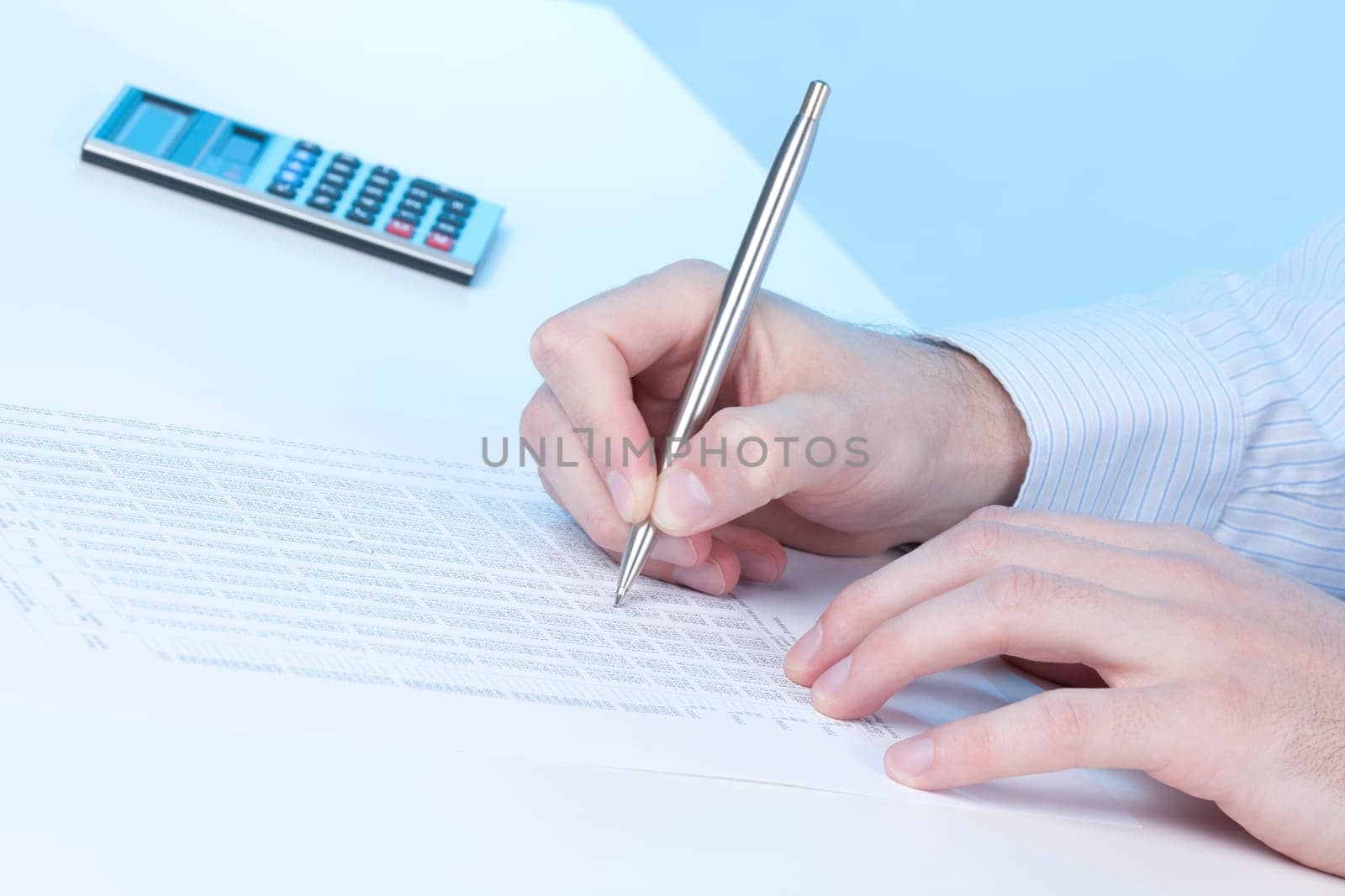 Economic analysis - hand with pen, sheet and calculator
