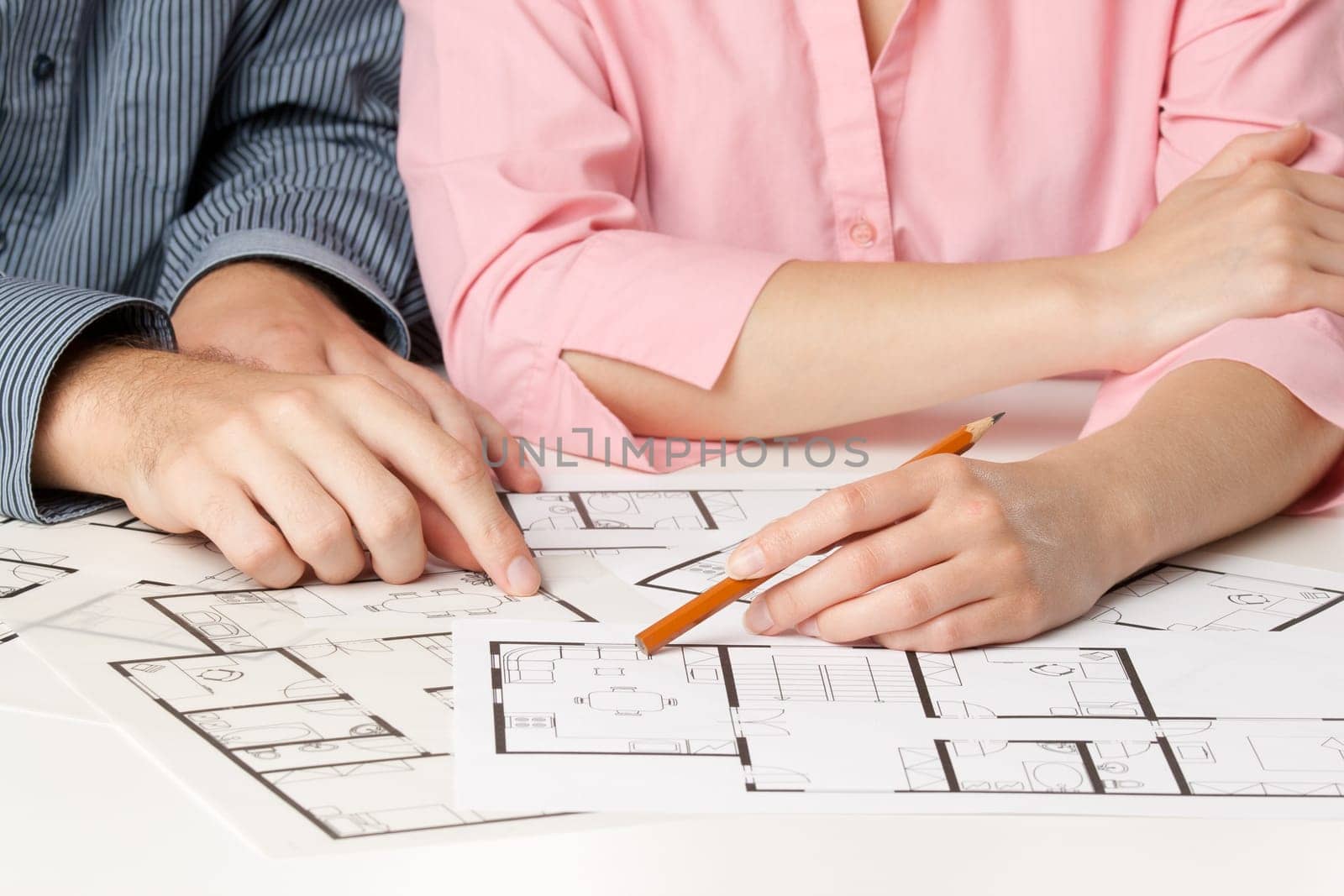 Young couple planning living together in new house with interior blueprints