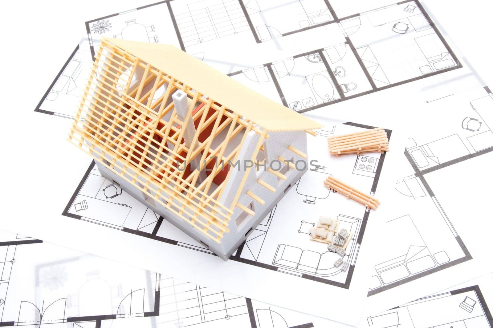 Building the house concept - model of the house with building material and blueprints, top view