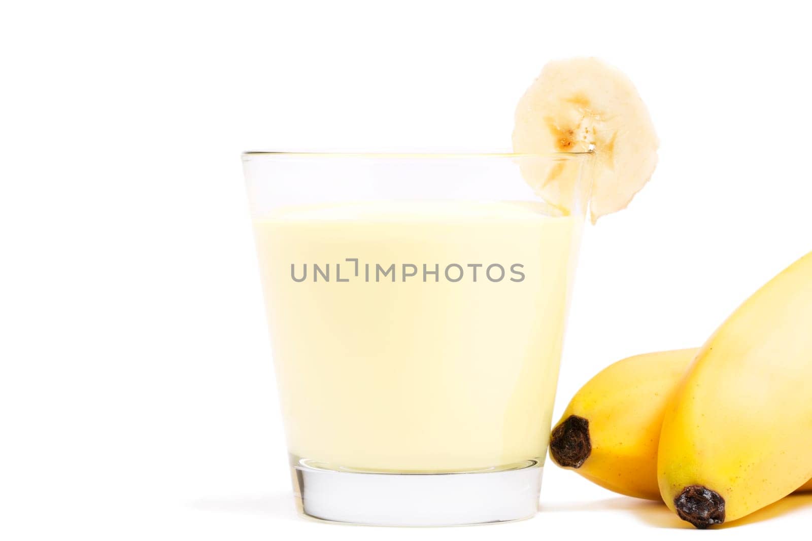 Bananas milkshake with bananas next to it on white background