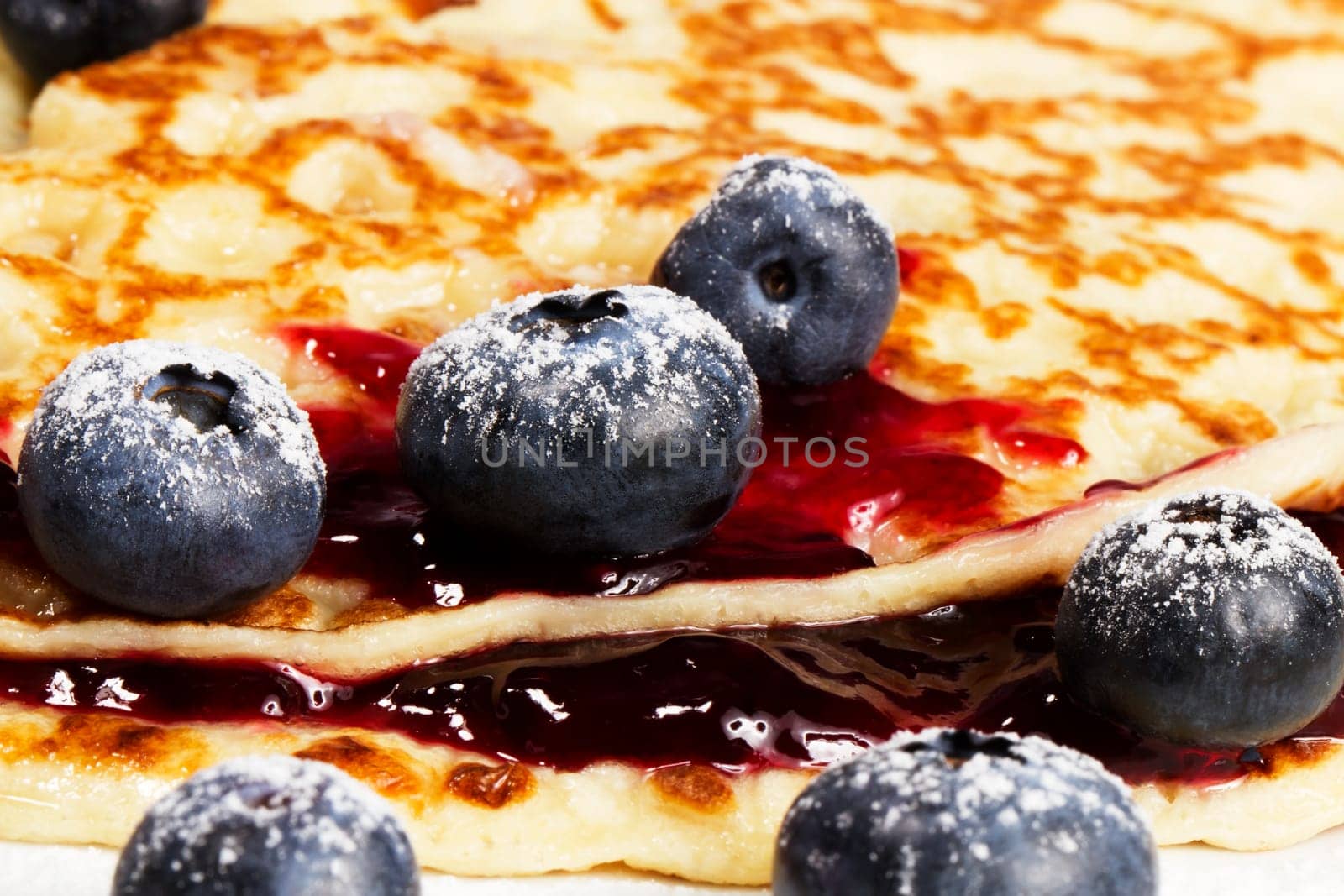 Close-up of blueberries on pancakes with blueberry jam