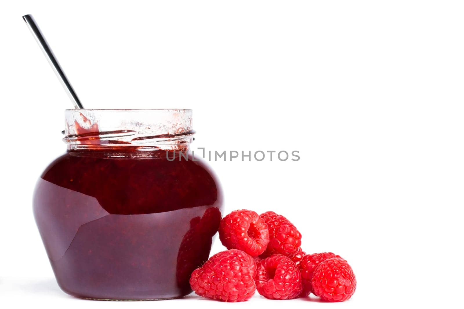 Jam jar with raspberries and a spoon on white background