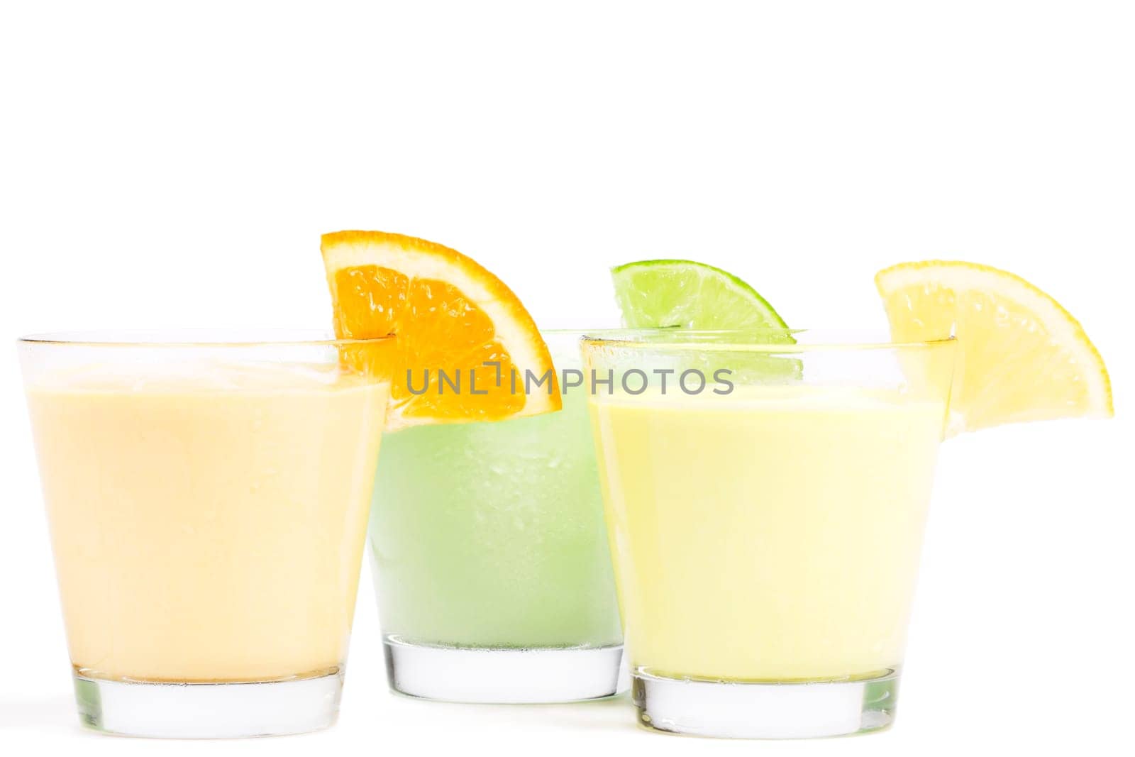 Three cold citrus milkshakes on white background