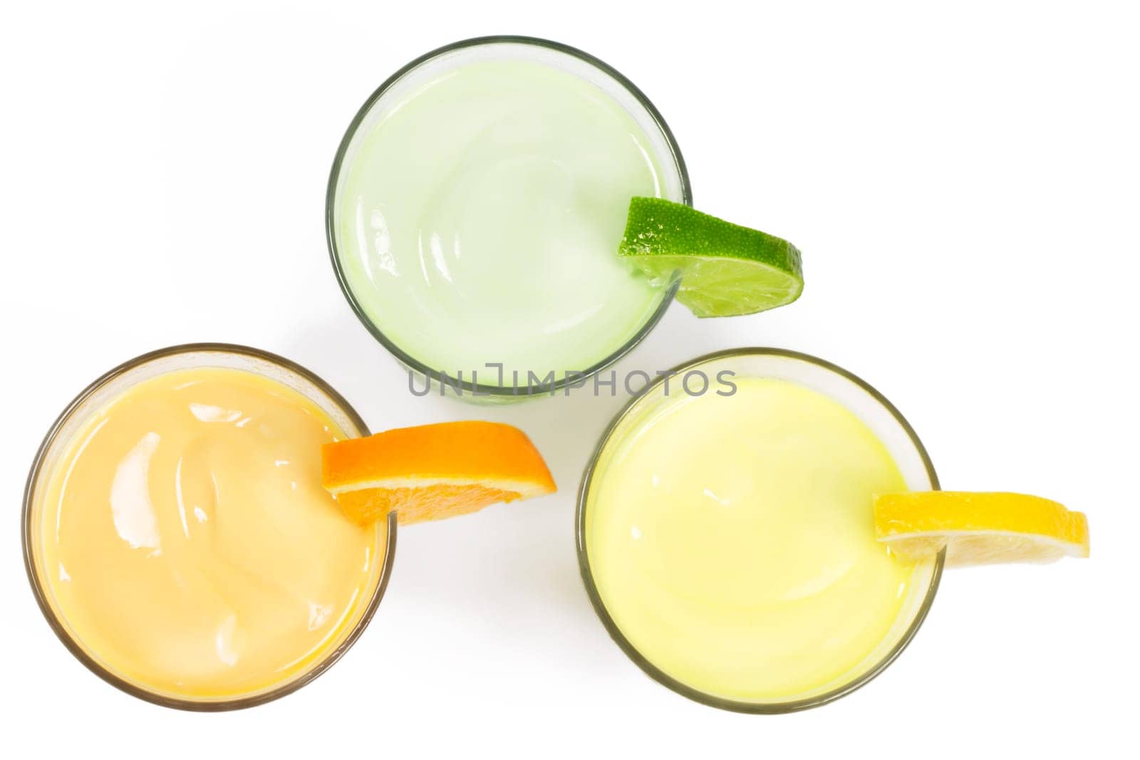 Three cold citrus milkshakes from above on white background