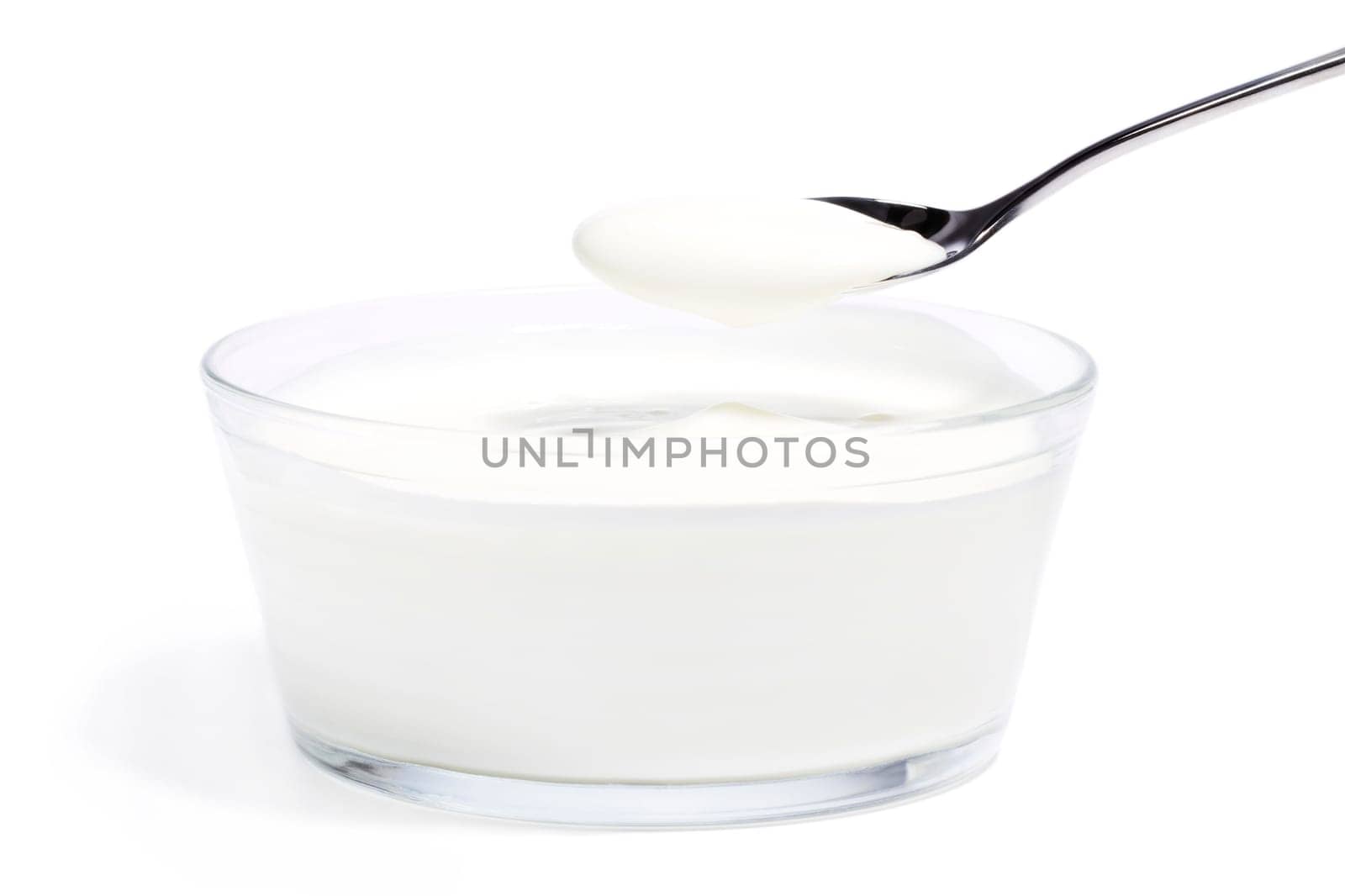 Yogurt in a bowl with a spoonful of yogurt on a white background