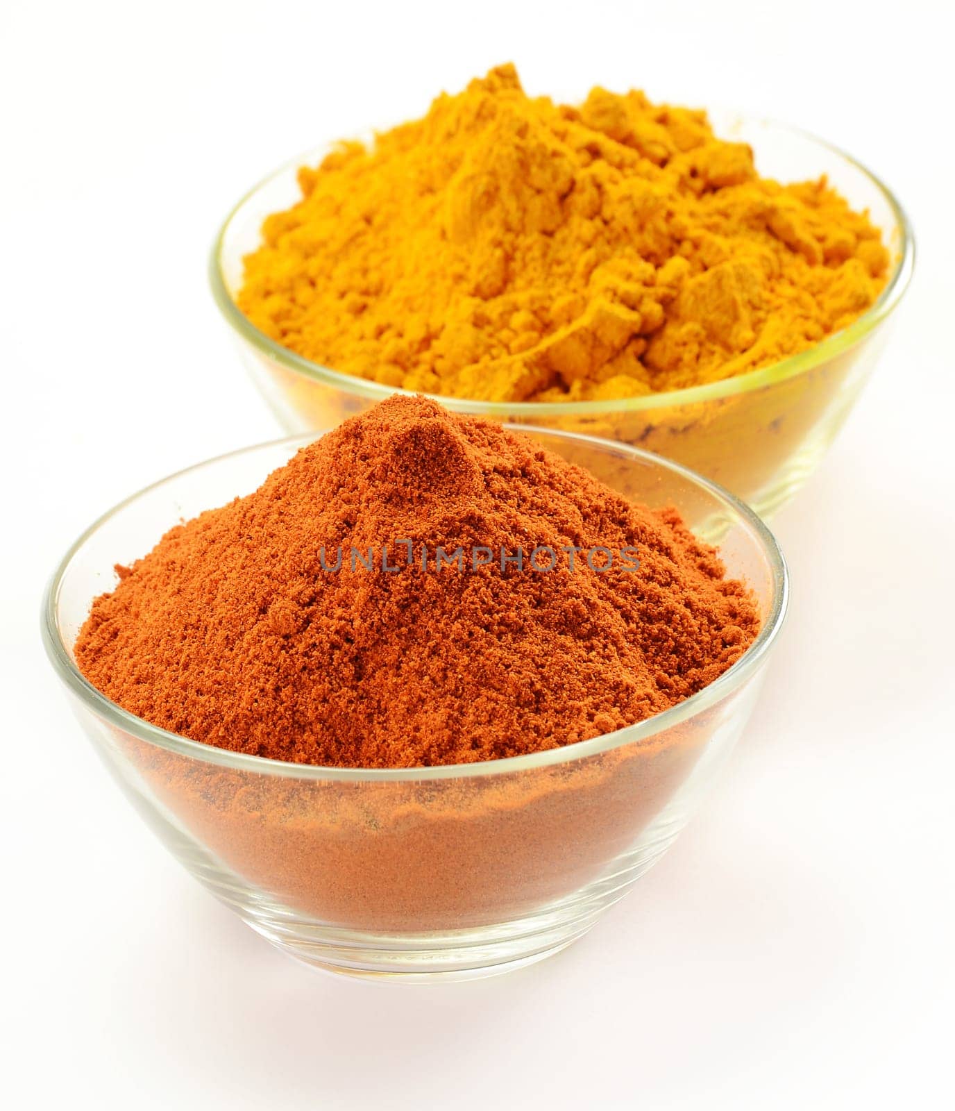 Small dishes with cayenne pepper and turmeric isolated on white