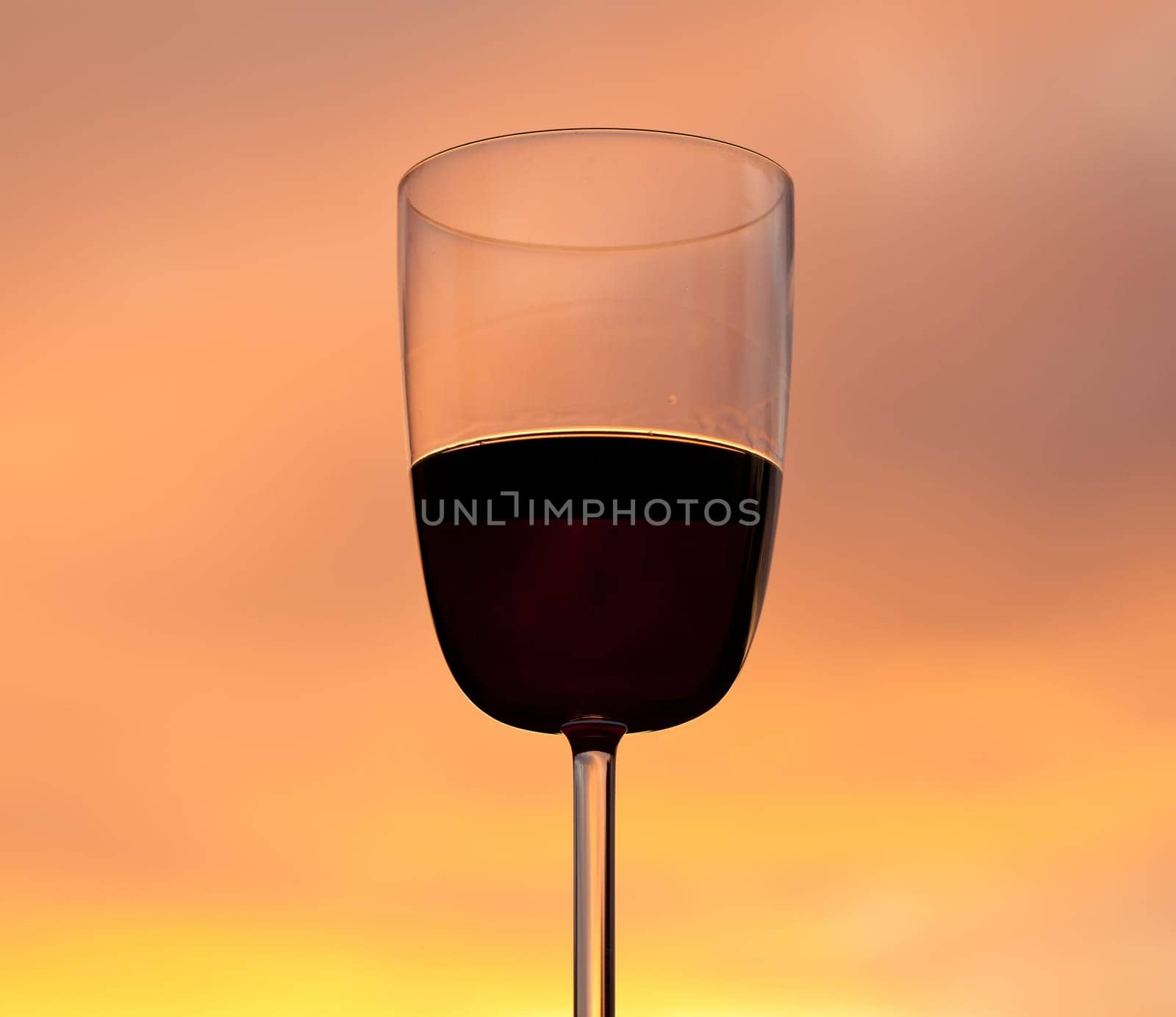 Relaxing with a glass of red wine set against the glowing orange of a brilliant sunset