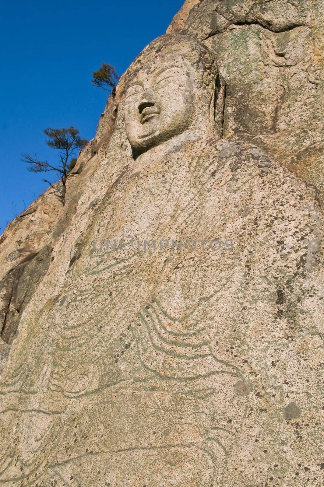 Ancient stone buddha carved into a hillside in Korea