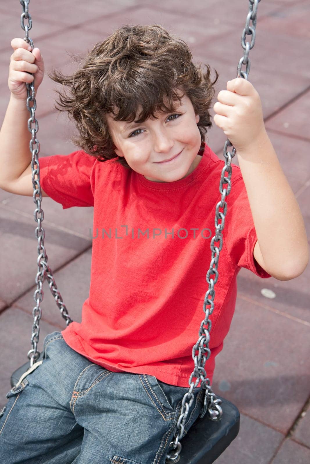 Happy child on the swing with red shirt
