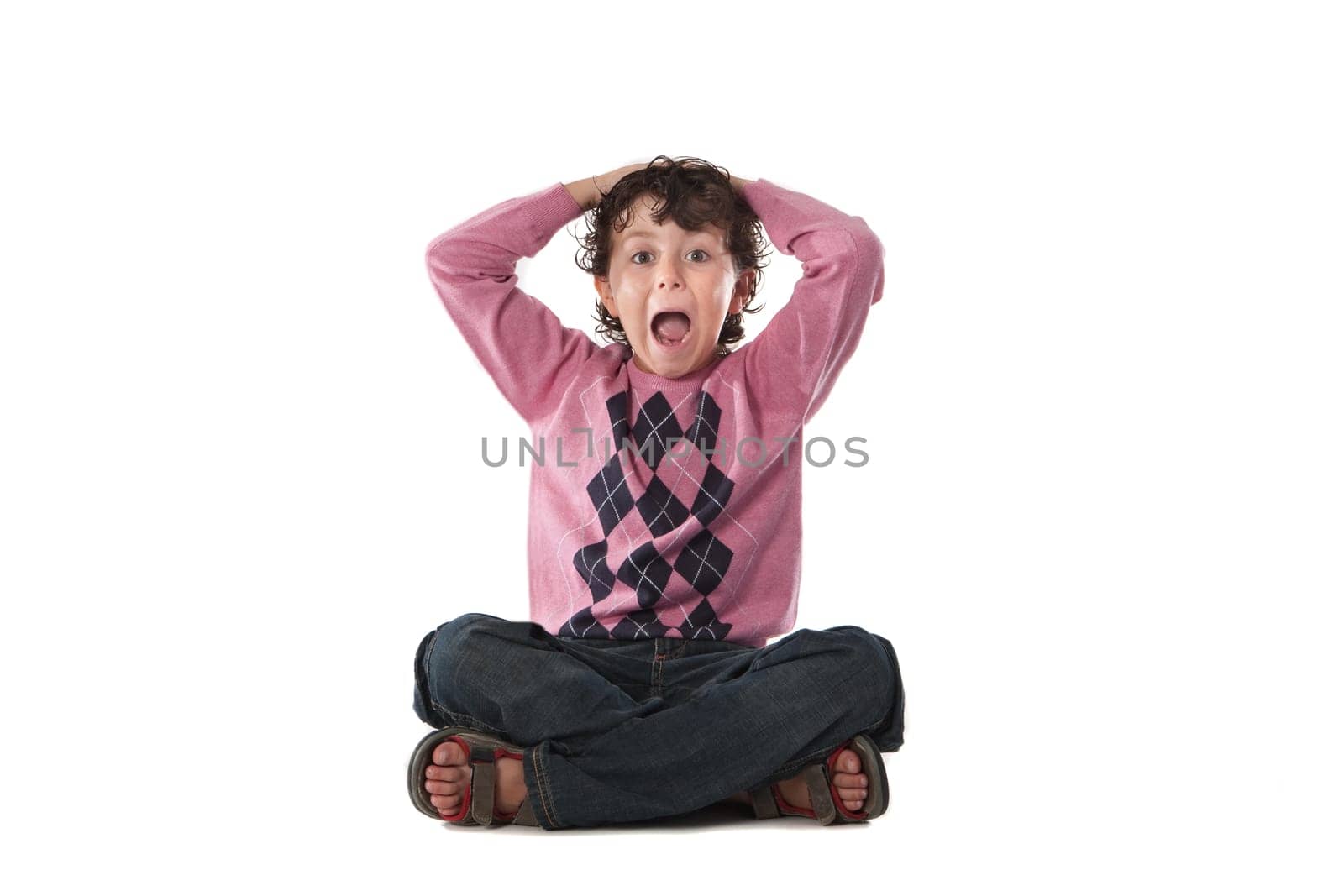 Surprised child sitting on a over white background