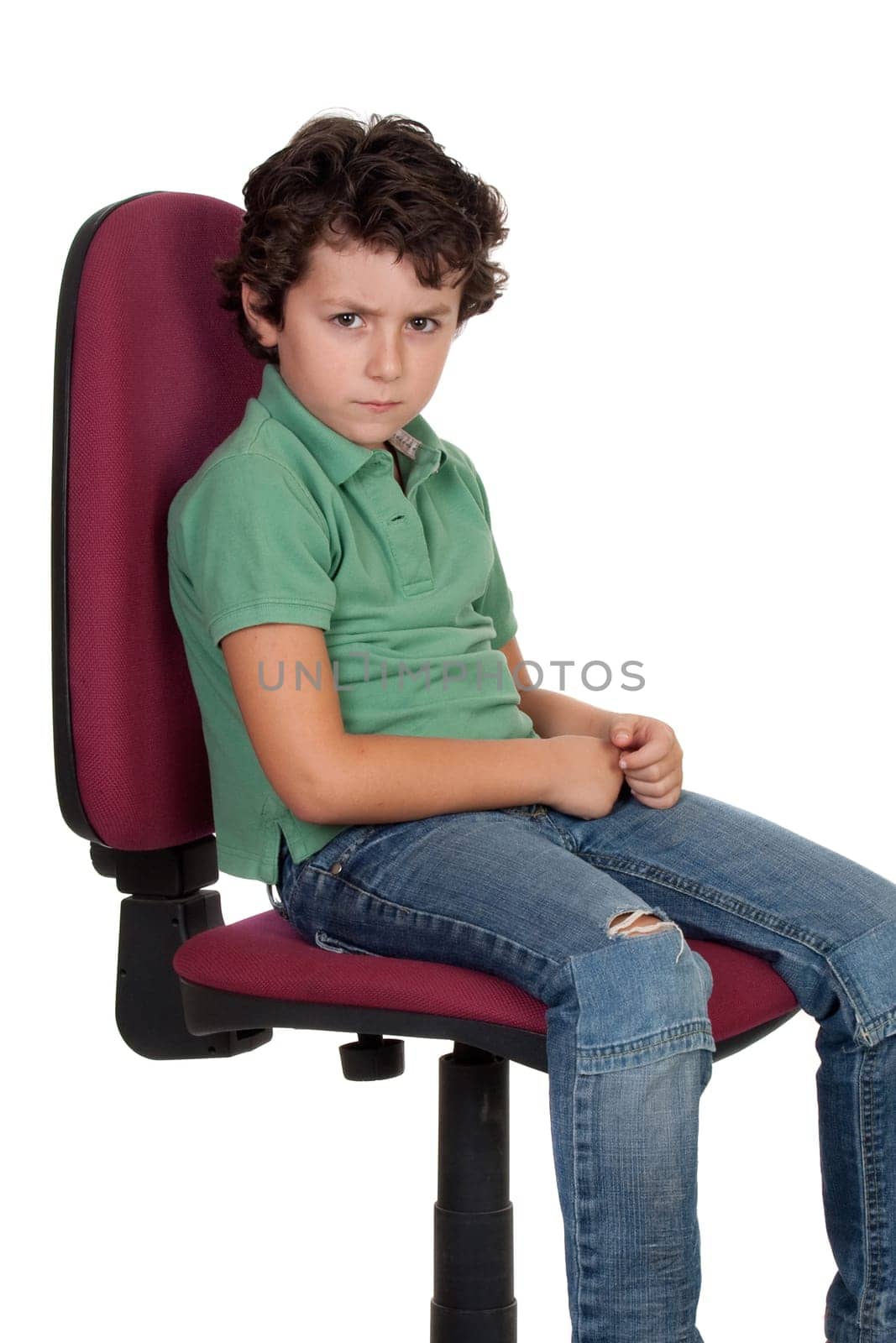 Angry little boy sitting on big chair isolated on white.