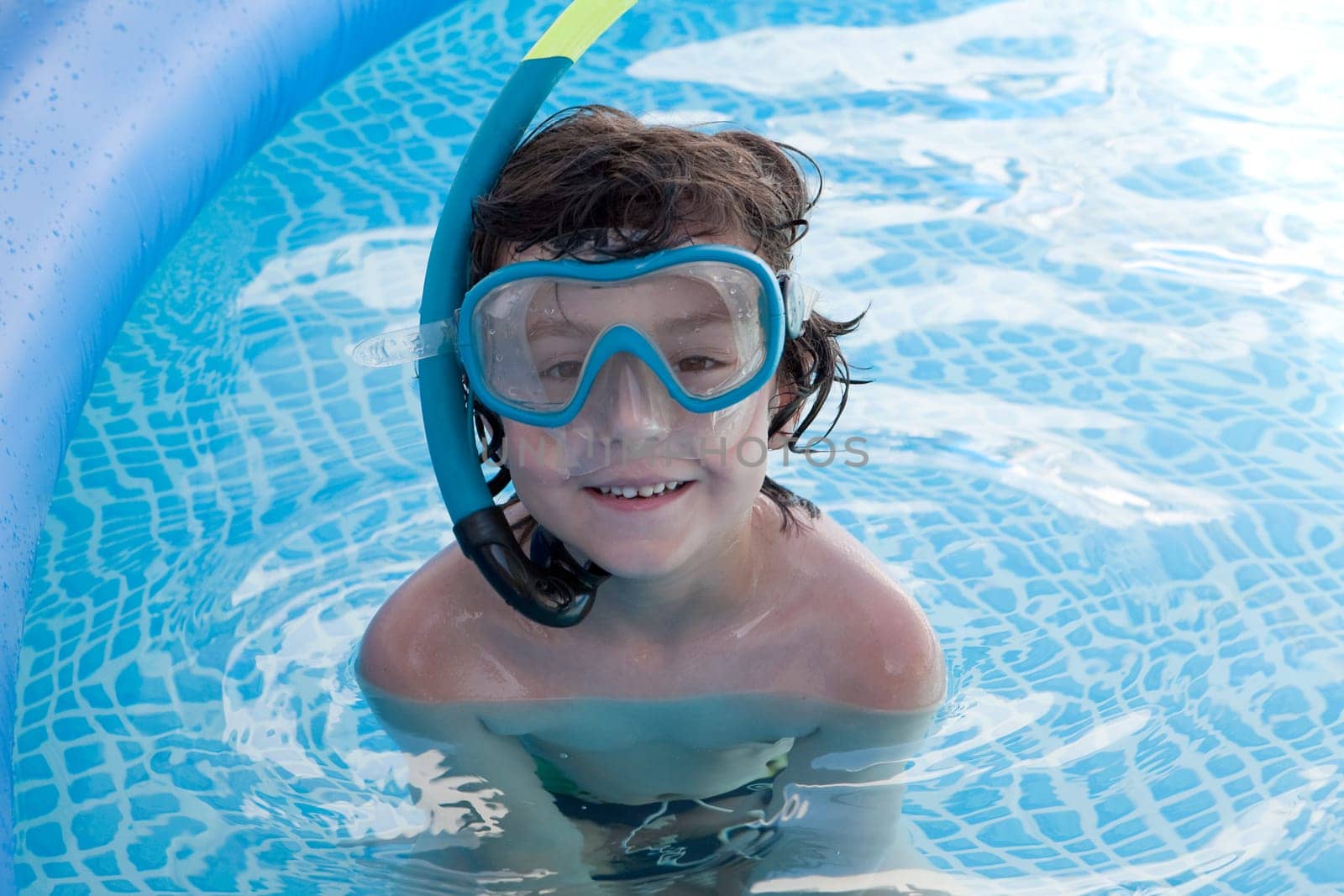 Child in the pool on holiday learning to swim