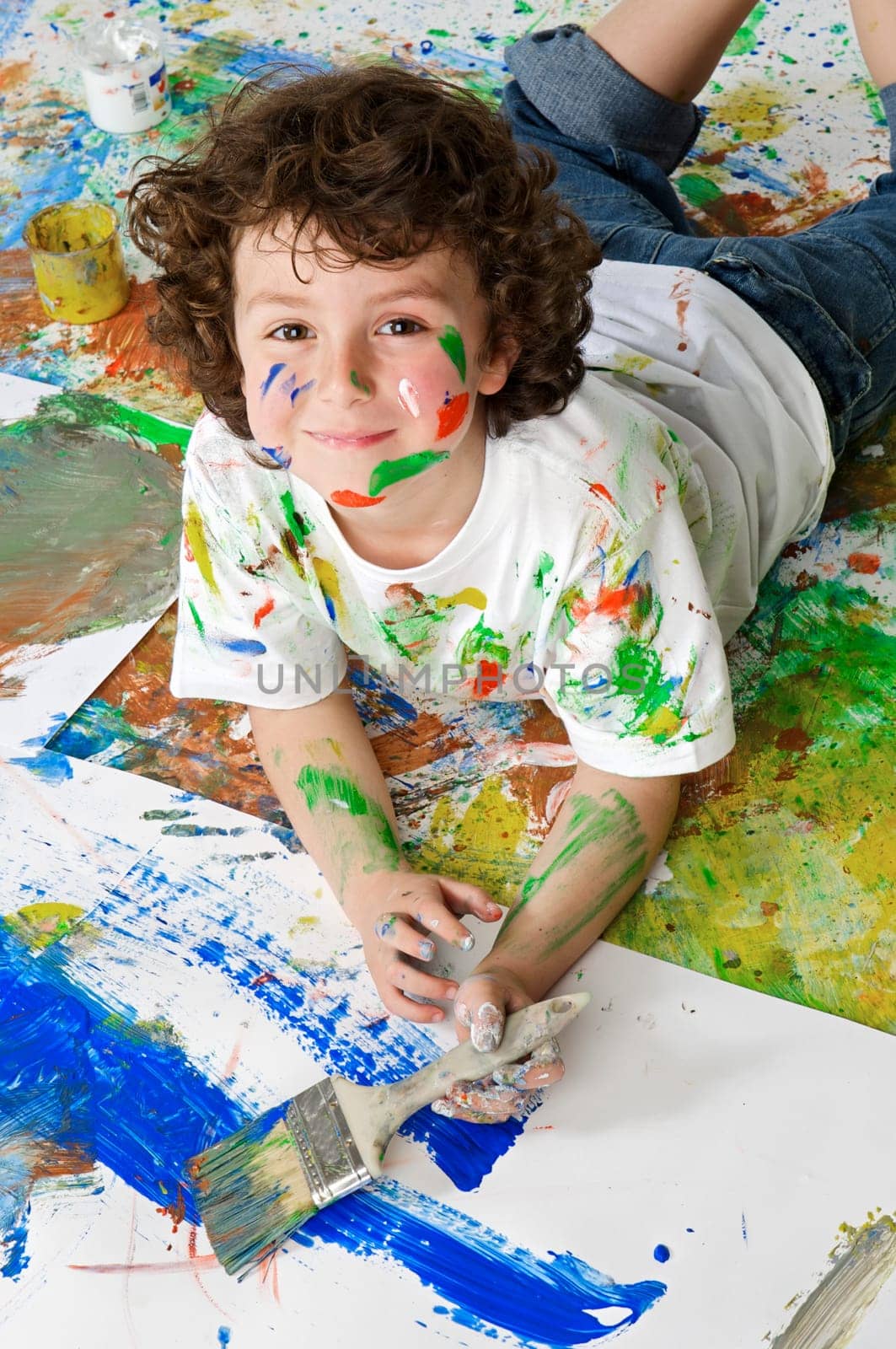 Handsome boy playing with painting with the background painted