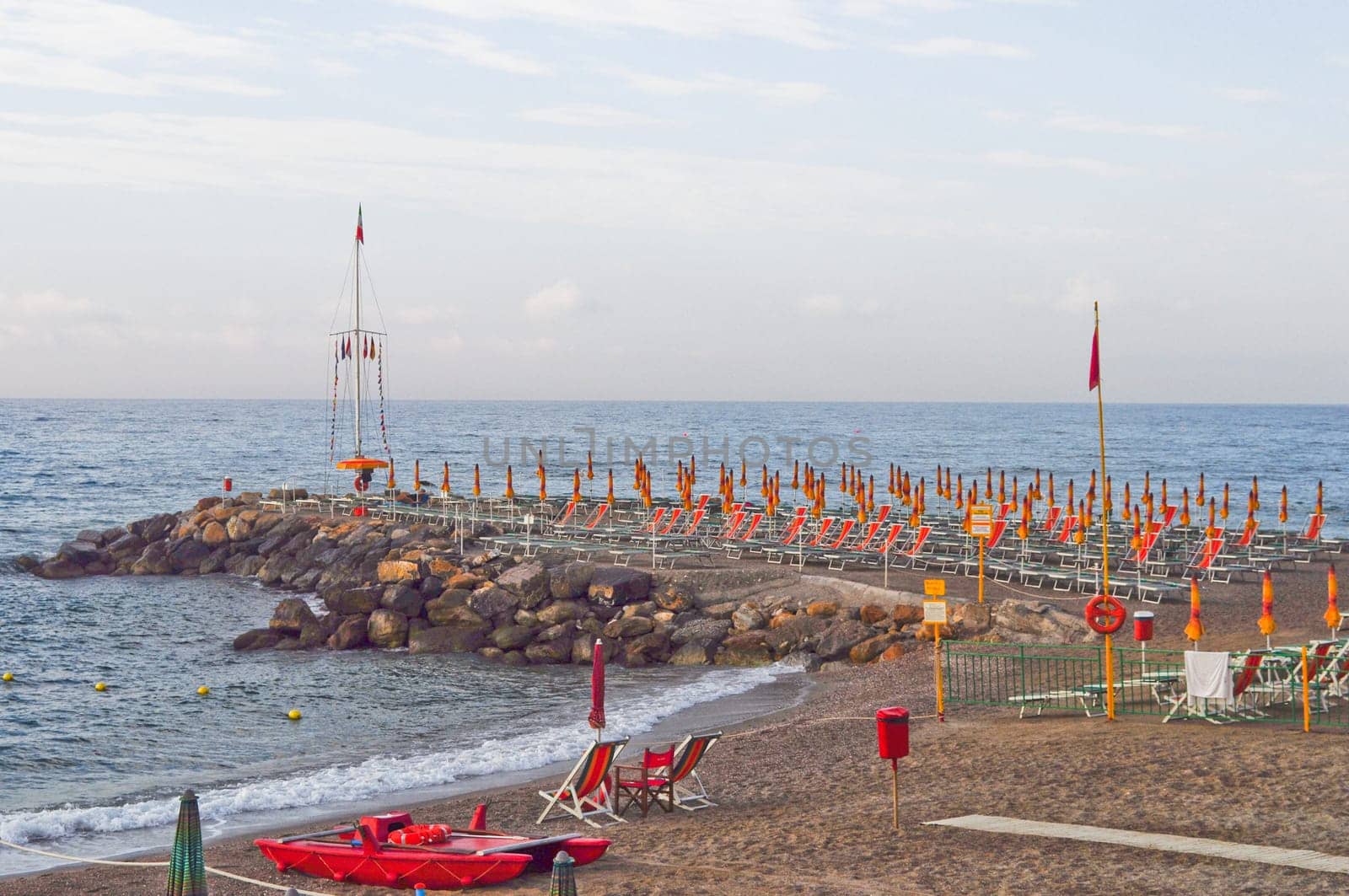 Shore beach with sun umbrella and deckchairs