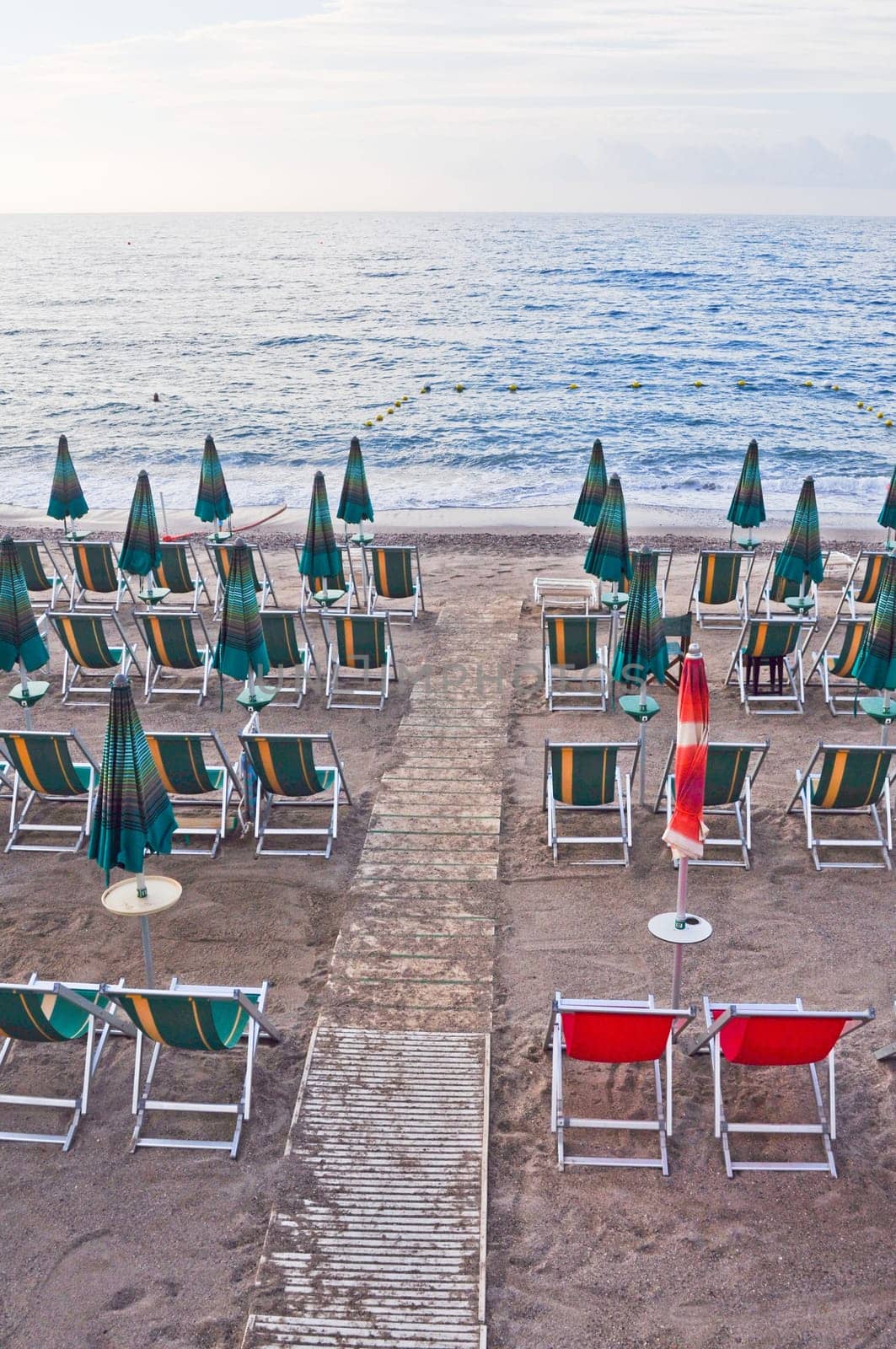 Shore beach with sun umbrella and deckchairs
