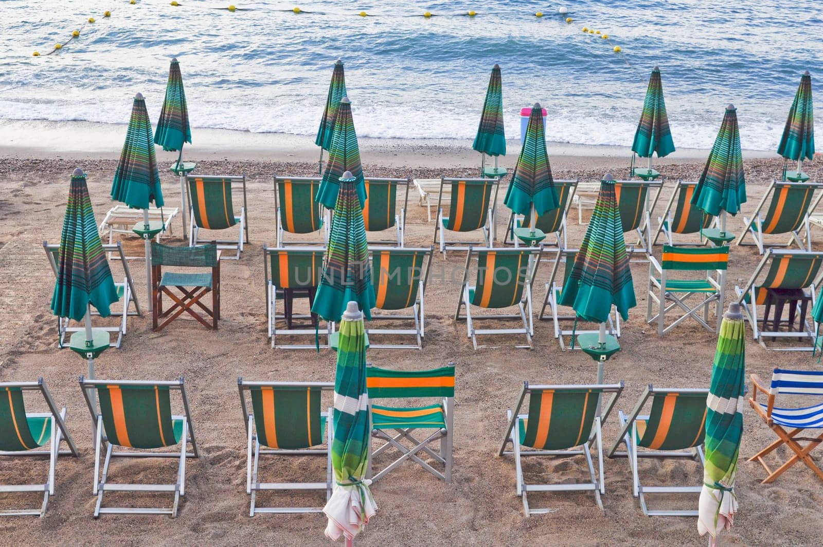 Shore beach with sun umbrella and deckchairs