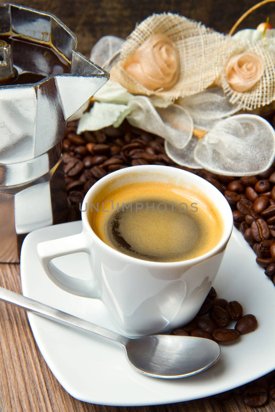 Coffee cup with burlap sack of roasted beans on rustic table