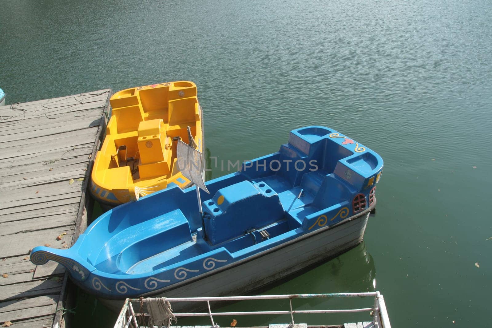 Bright blue and yellow boats at the boarding platform in a lake