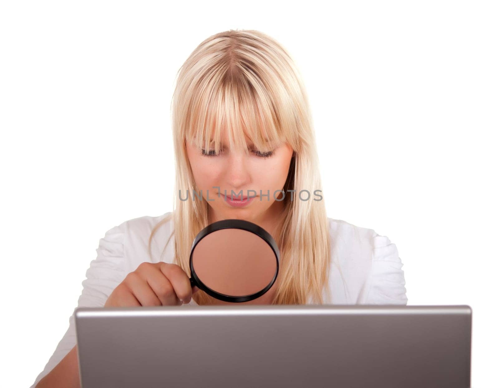 Blonde young woman with magnifying glass and laptop
