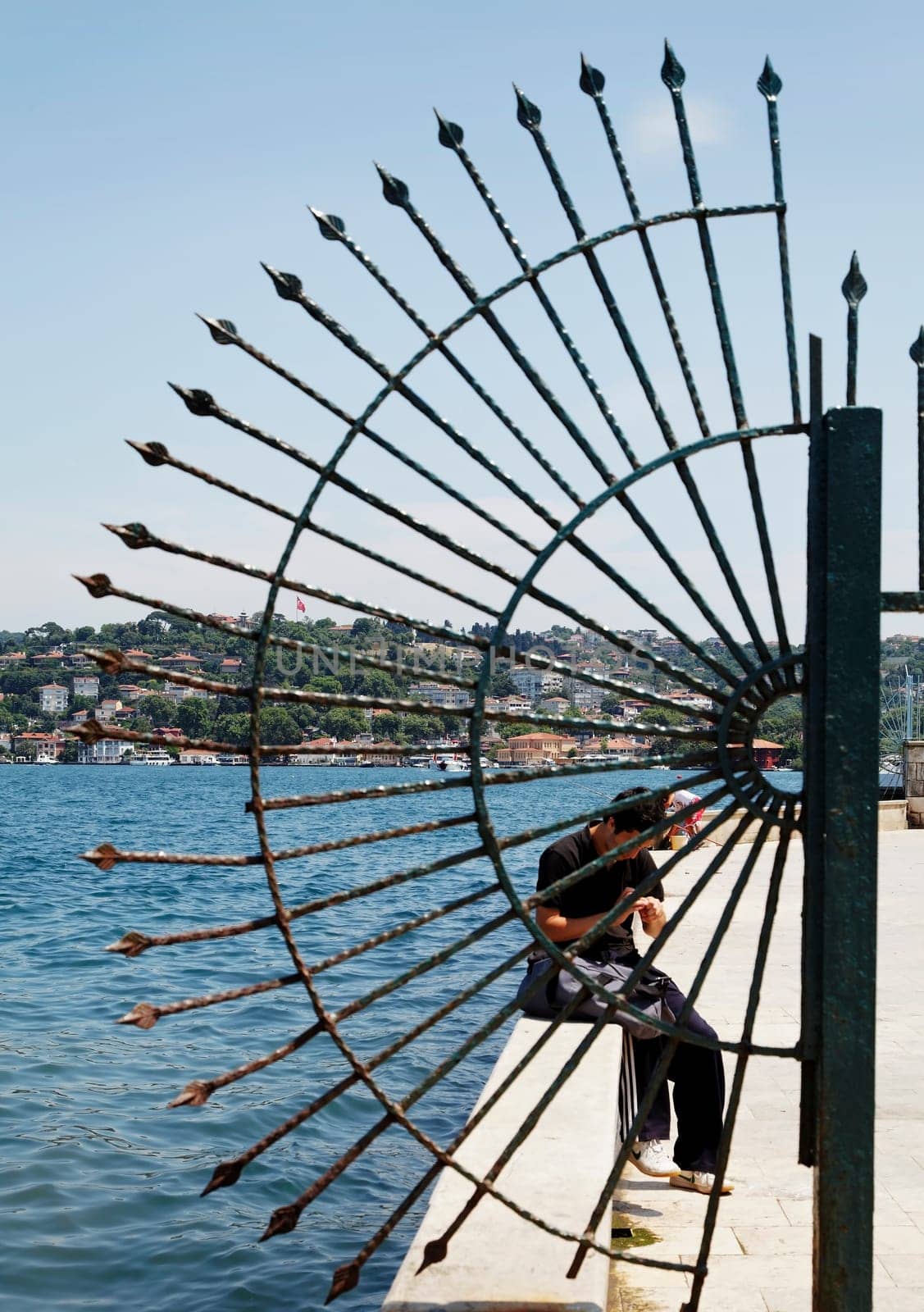 creative shot of Istanbul fishermans wharf and quayside through crescent railings, portrait, crop space