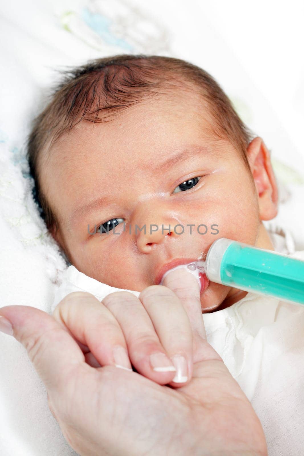little boy drinking milk from the mother of the syringe