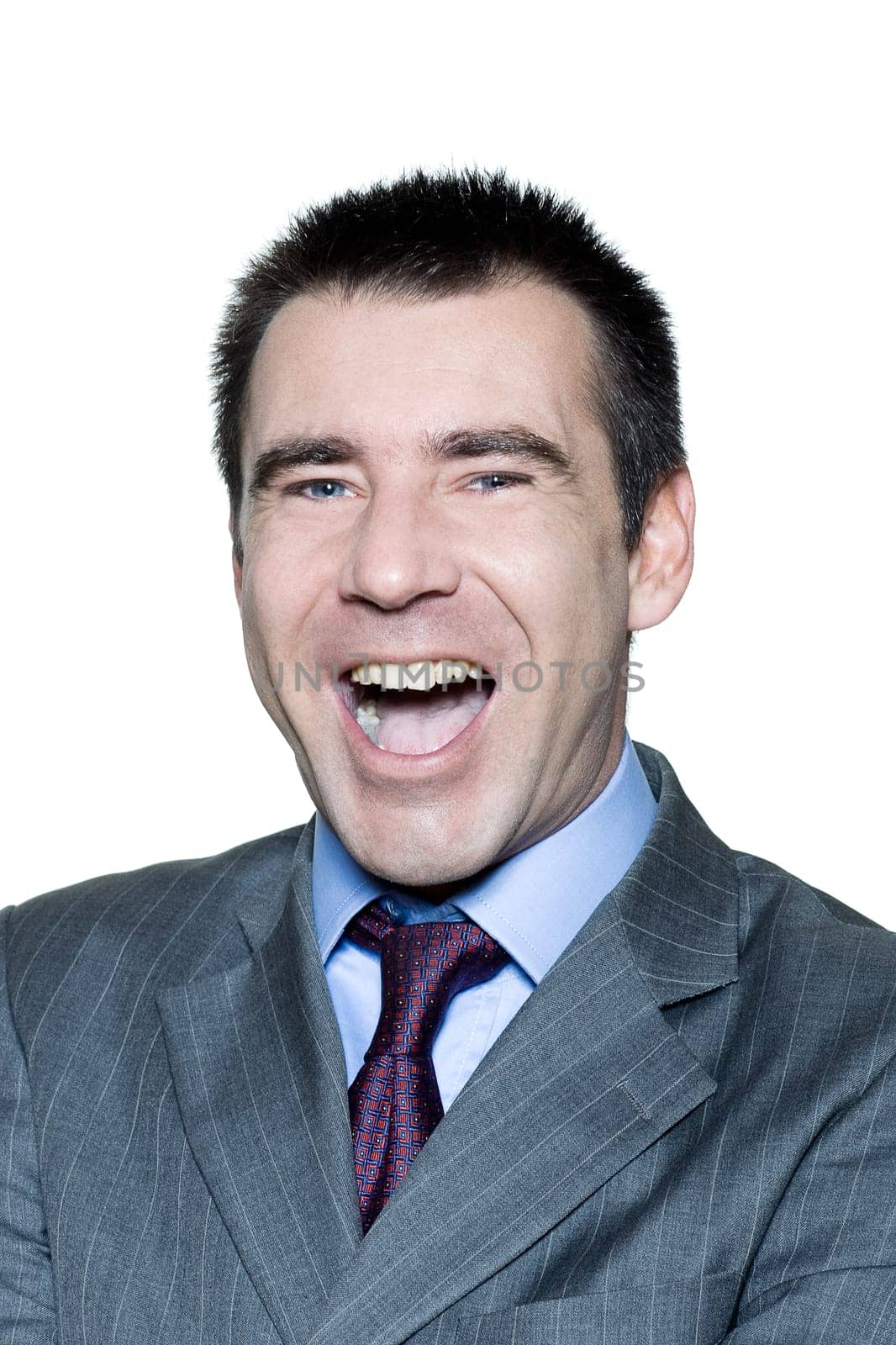 Closeup portrait of an expressive handsome man laughing in studio on isolated white background