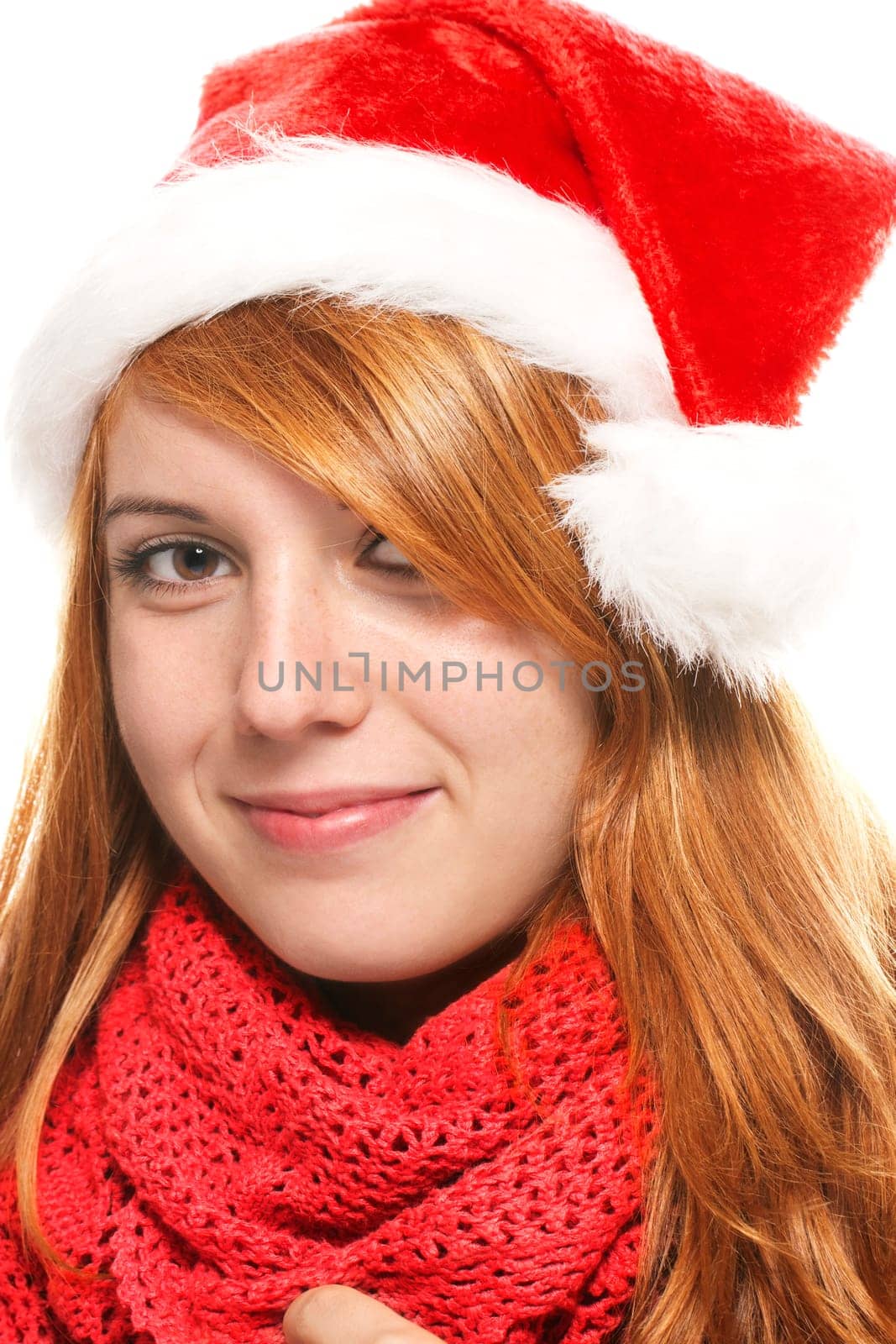 Portrait of a young smiling woman in a Santa hat against a white background