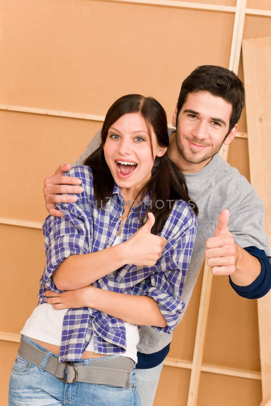Home improvement young couple having fun new house thumb up