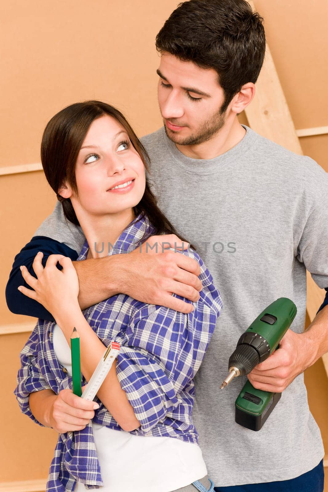 Home improvement young happy couple with repair tool hand drill ruler