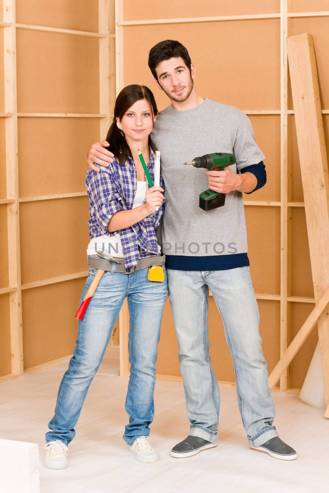 Home improvement young happy couple with repair tool hand drill ruler