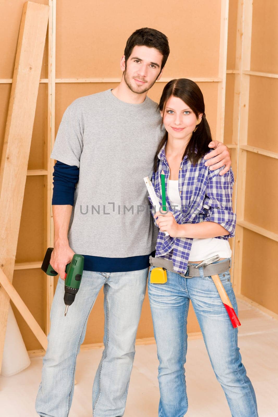 Home improvement young happy couple with repair tool hand drill ruler
