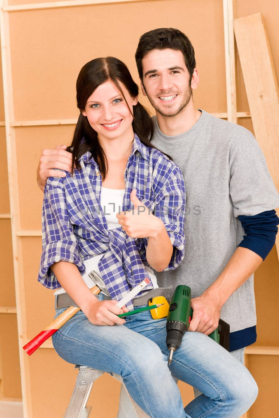DIY home improvement young happy couple with hand drill ruler