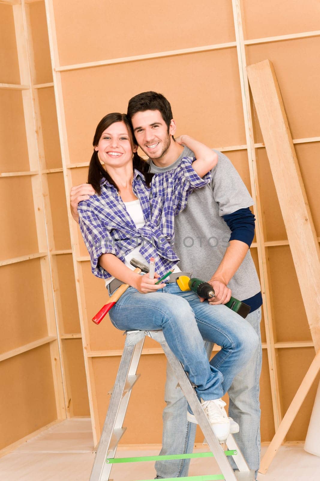 Home improvement young happy couple with repair tool hand drill ruler