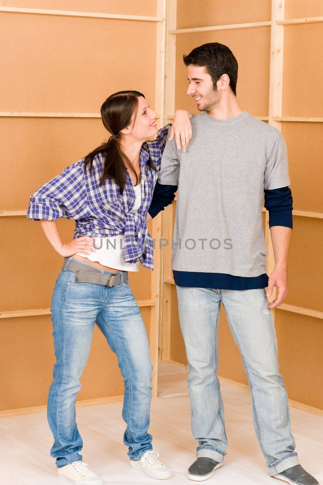 Home improvement young couple looking at each-other in new house